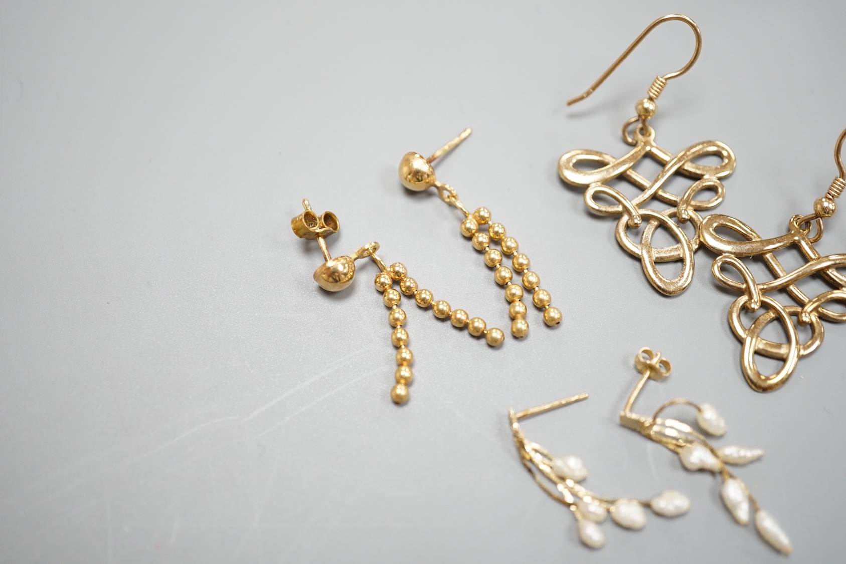 Two pairs of modern 9ct gold earrings including interwoven and tassel drop, 6.5 grams and a pair of 14k and baroque pearl drop earrings, gross 0.9 grams.